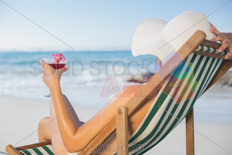 Stock Photo of Woman relaxing in deck chair with cocktail