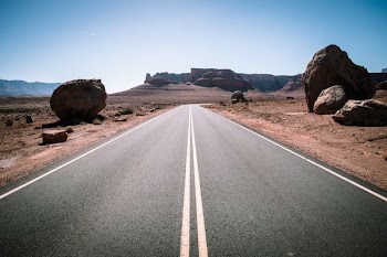 straight line road in the middle of desert