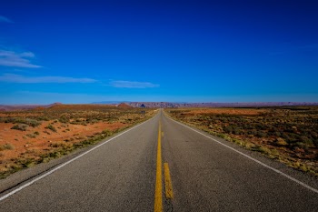 Straight Road Surrounded With Grass