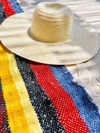 Straw Hat on a Multi-colored  Knitted Textile