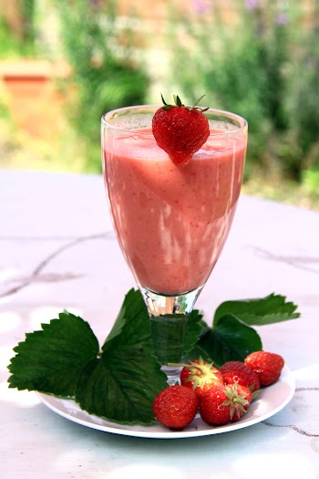 Strawberries on a Plate Beside Strawberry Shake in a Clear Glass