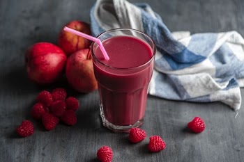 strawberry juice beside strawberry fruits