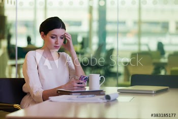 Stressed corporate businesswoman using smart phone in office