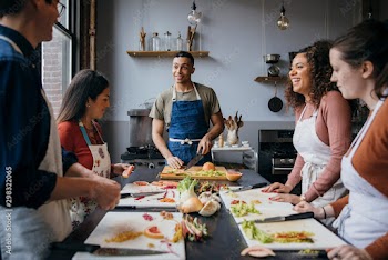 Students practicing chopping on table in training class