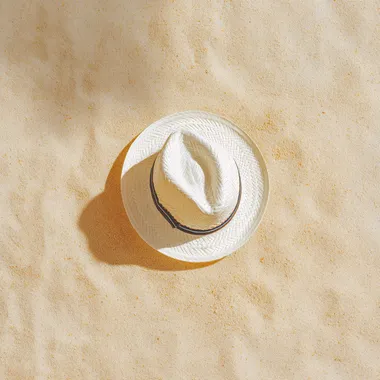 Stylish White Hat on Sandy Beach Stylish White Hat on Sandy Beach