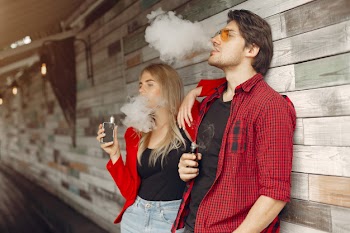 Stylish young couple with vape in a city Free Photo