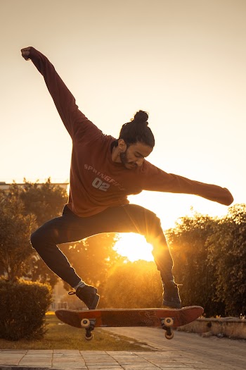 Sun Rays Coming Through Man Wearing Red Crew-neck Long-sleeved Shirt Skateboard