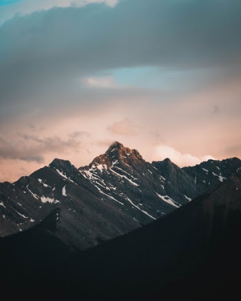 Sunlight illuminates the peak of a glacier encompassing the town of Banff