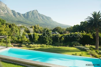 Sunny luxury lap pool with scenic mountain view
