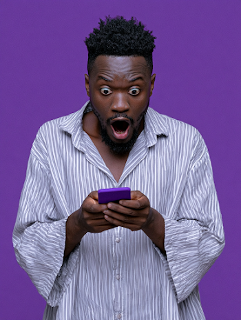 Surprised Young Black Man with Smartphone