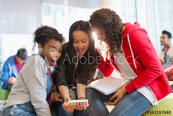 Surprised young female college student using smart phone in lounge