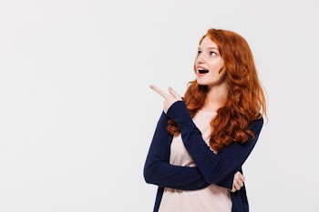 Surprised young redhead lady pointing Free Photo