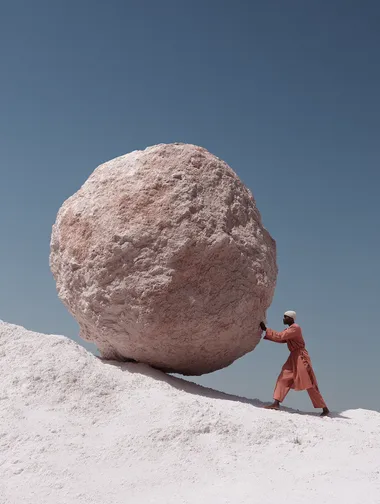 Surreal Fashion Depiction of Sisyphus with Salmon-Coloured Boulder Surreal Fashion Depiction of Sisyphus with Salmon-Coloured Boulder