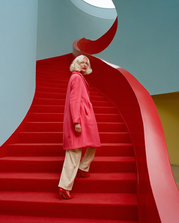 Surreal Fashion Journey: Elegant Woman on Bright Red Stairs