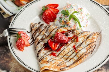 Sweet crepe with powder and strawberries Free Photo
