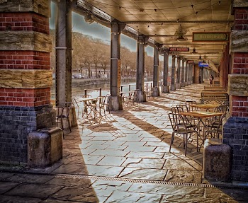 Table and Chairs Inside Tunnel Beside Body of Water