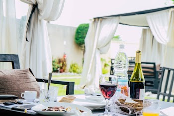 Table Full With Plate of Foods, Wine Bottle, and Mugs