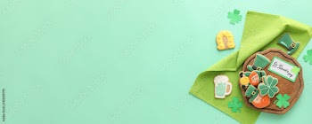 Tasty gingerbread cookies for St. Patrick's Day celebration on color background with space for text