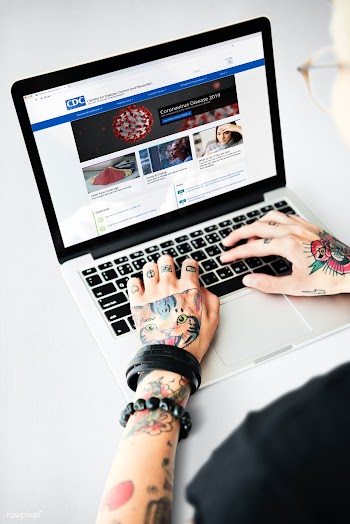 Tattooed man reading coronavirus updates from a laptop mockup with edi.. | Free  photo - 2312604