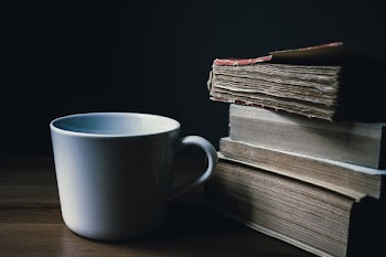 Tea mug and a pile of books