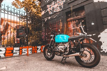 Teal and Black Motorcycle Near Gate