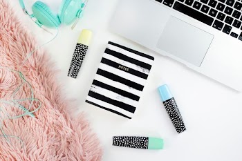 teal full-size corded headphones beside silver MacBook