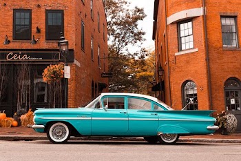 teal sedan park beside street during daytime