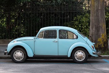 teal Volkswagen Beetle parked beside road