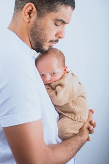 Tender Moments: Father Holding Newborn Baby