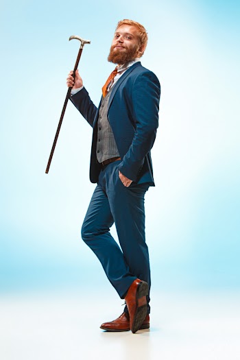 The barded man in a suit holding cane. Free Photo