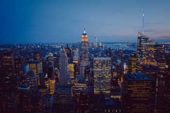 The beautiful view to the skyline & the Empire State Building in the moody blue hour of New York City.