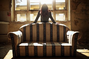 the girl bowed down stand behind the sofa