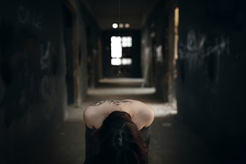 The girl bowed head in the gloomy aisle