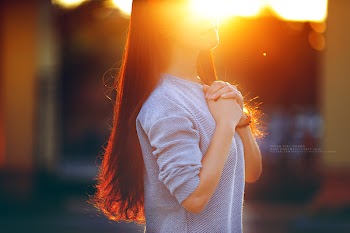 The girl is praying in the sunset