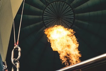 The interior of a hot air balloon as flames burn hard to elevate the balloon.