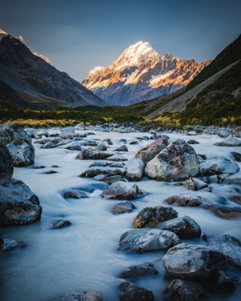 The light of the setting sun hits Mt Cook with the glacial water of the Hooker River in the foreground. This was just off the Hooker Valley Track in New Zealand. The hike was awesome, and hard to beat in the views per mile/difficulty level. It's a relatively short, flat hike that has 3 cool bridges and great views in every direction. 