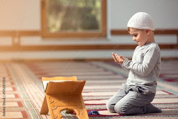 The Muslim child prays in the mosque, the little boy prays to God, Peace and love in the holy month of Ramadan.