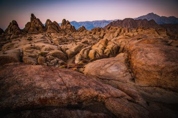 The pastel hues of sunrise illuminate the rocks of the Alabama Hills in California, USA. 