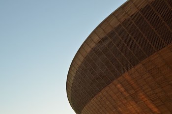 The saucer-like facade of a sports arena against blue sky