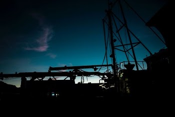 The silhouette of equipment on a boat at dusk in Hoonah