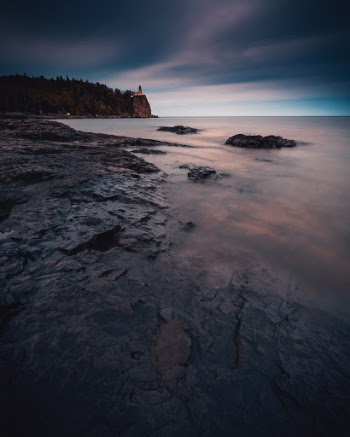The sun sets on stormy skies at Split Rock Lighthouse State Park, MN, USA.