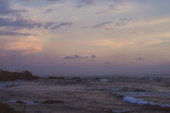 The waves of the ocean are breaking against the rocks. splashing ocean waves at sunset.