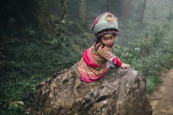 This Hmong girl was sitting by herself on a rock five times her size and singing.