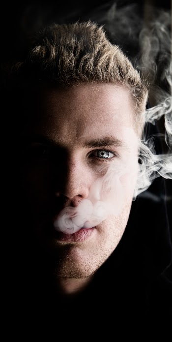 This photo stands out a lot, in comparison to my other low light ( Low key ) shots this one up the stakes due to composition, the added smoke, the facial structure and the bright tones caught in the subjects eye. I achieved this high-resolution photo through Nikon's 48megapixel camera D850. Which allowed me to underexpose the image enough to contrast the light v dark whilst maintaining an unpixelated/noiseless image that I could further edit to amplify its end result. The smoke and eye catch the focus vs the previous shots that only catch the eye. 