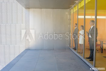 Thoughtful business people looking out modern office window