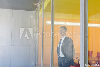 Thoughtful corporate businessman looking out office window