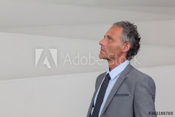 Thoughtful corporate businessman looking up in suit