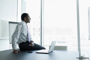 Thoughtful corporate businessman with laptop in conference room