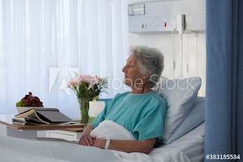 Thoughtful female senior patient in hospital bed
