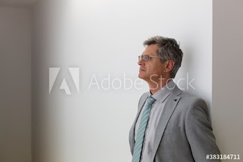 Thoughtful mature corporate businessman looking away